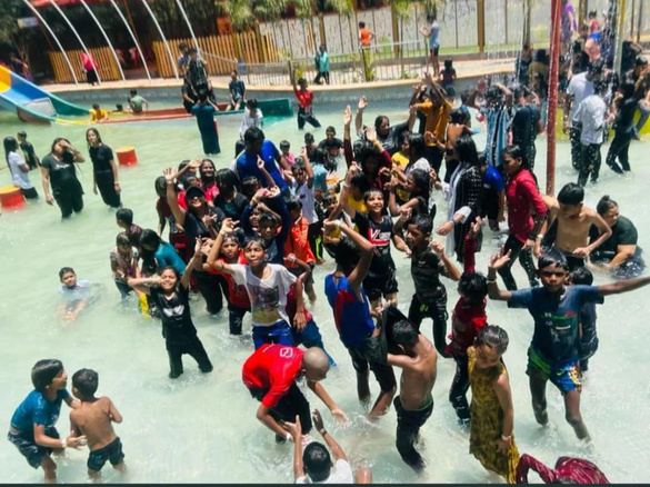 Children playing together in a water park pool during an annual picnic.
