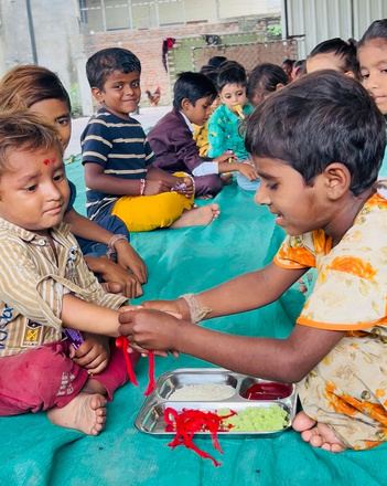 A girl tying a rakhi on a boy's wrist during Raksha Bandhan.