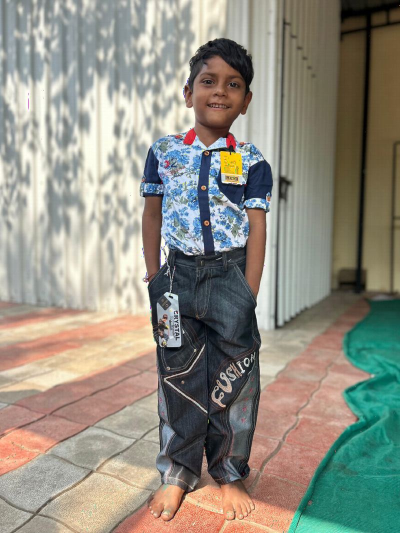 A boy wearing new clothes with the tag still attached.