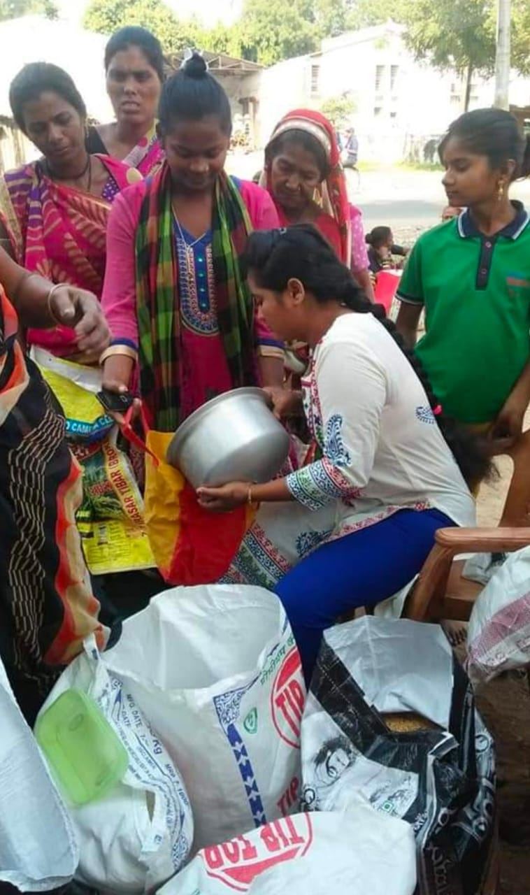 A volunteer serving food from a large pot.