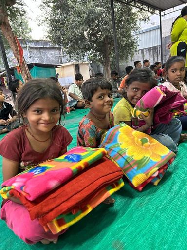 Smiling children holding new colourful blankets.