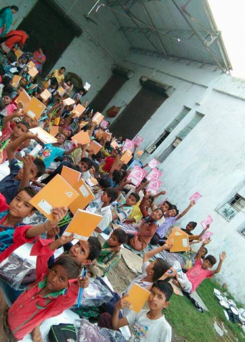 Children raising new notebooks in the air.