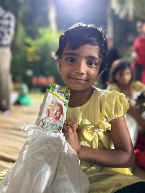 A smiling girl holding a gift.