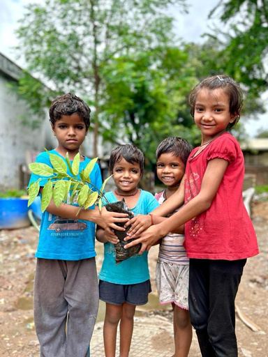 Children holding a young plant ready for planting.
