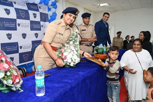 A uniformed officer presenting flowers to a child at a foundation event.