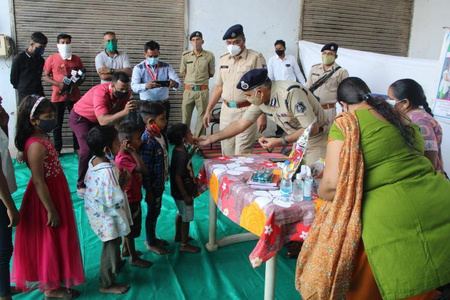 Uniformed officers and volunteers with children around a table.