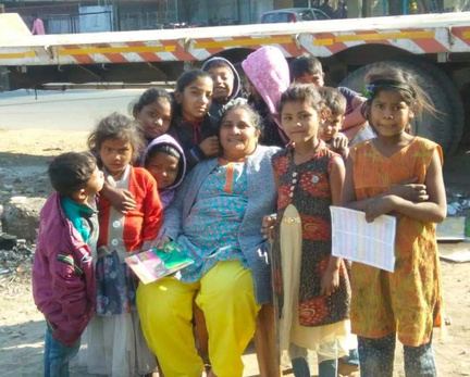A volunteer smiling with a group of children.