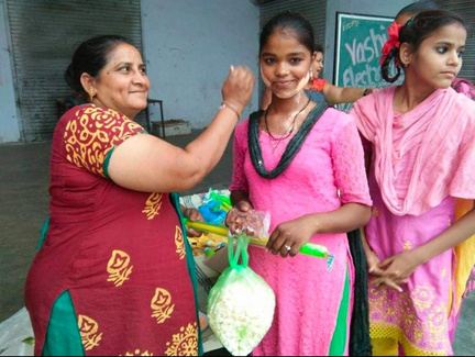 A volunteer smiling with two girls.